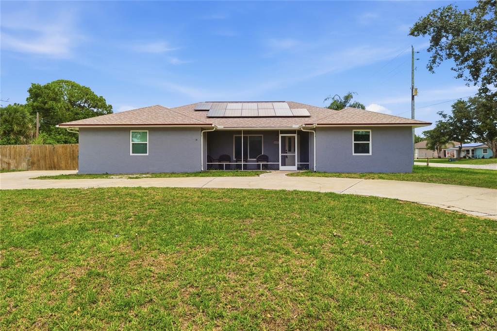 A gray single-story house with a concrete driveway and a screened-in back porch — 602 LAKE DRIVE, SEBASTIAN, FL