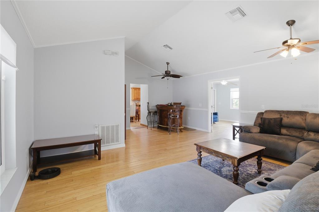 A living room features a large sectional sofa, a coffee table, and a vaulted ceiling — 602 LAKE DRIVE, SEBASTIAN, FL