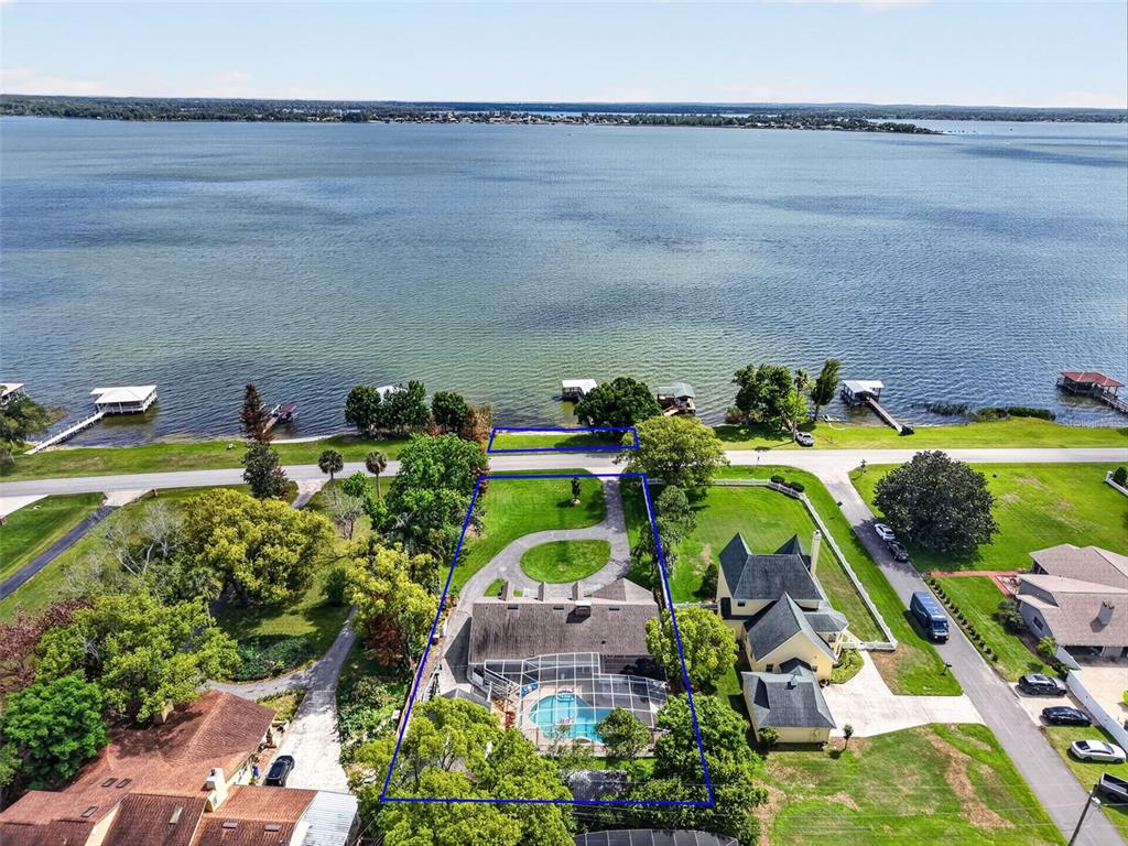 An aerial view shows a waterfront house with a screened pool and a circular driveway — 1735 LAKESHORE DRIVE, MOUNT DORA, FL