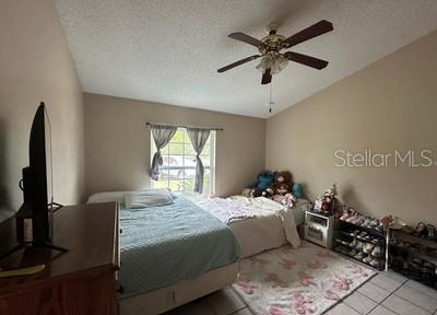A bedroom features two beds, a ceiling fan, a window with curtains, and shoe racks — 4 PINE CIRCLE DRIVE, OCALA, FL