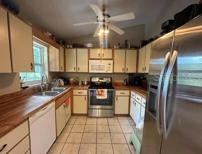 A kitchen features light-colored cabinets, stainless steel appliances, a tile floor, and wood countertops — 4 PINE CIRCLE DRIVE, OCALA, FL