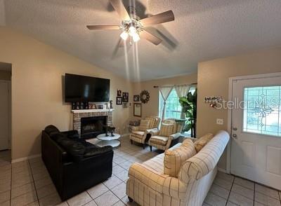 A living room features a fireplace, a black sofa, two armchairs, and a ceiling fan — 4 PINE CIRCLE DRIVE, OCALA, FL