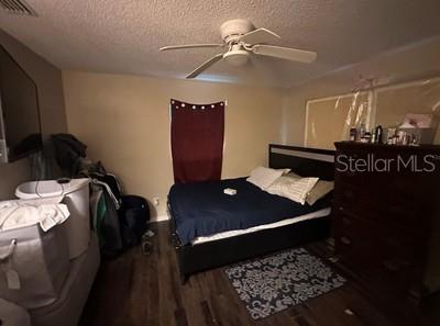 A bedroom featuring a bed, a dark wood dresser, a ceiling fan, and wood-look flooring — 4 PINE CIRCLE DRIVE, OCALA, FL