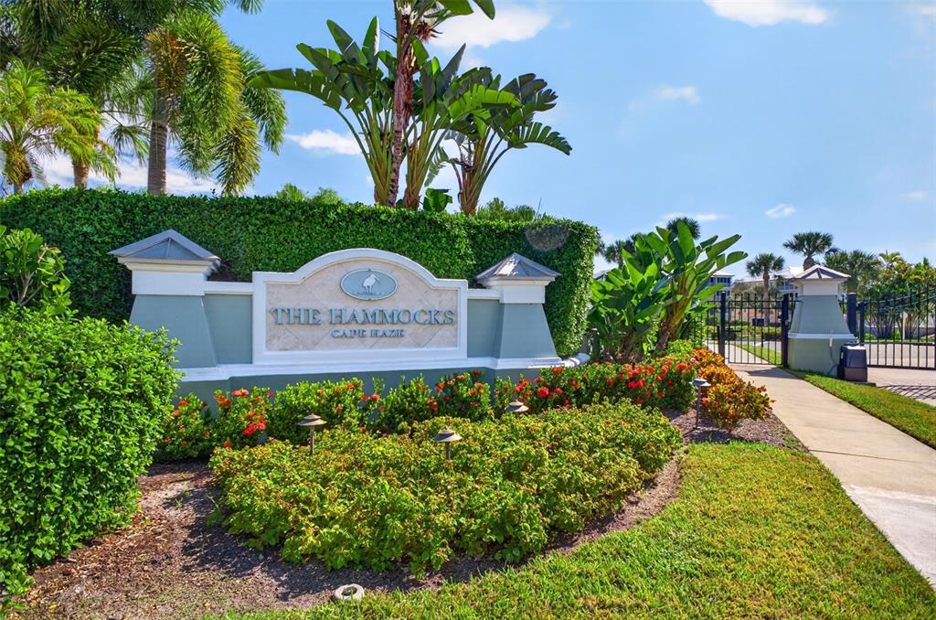 An aerial view shows a multi-story yellow apartment building with a metal roof and landscaping — 8561 AMBERJACK CIRCLE UNIT 302, ENGLEWOOD, FL