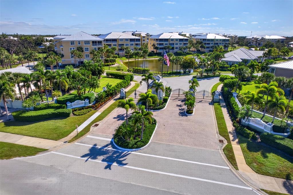 A multi-story beige apartment building with balconies and palm trees at dusk — 8561 AMBERJACK CIRCLE UNIT 302, ENGLEWOOD, FL