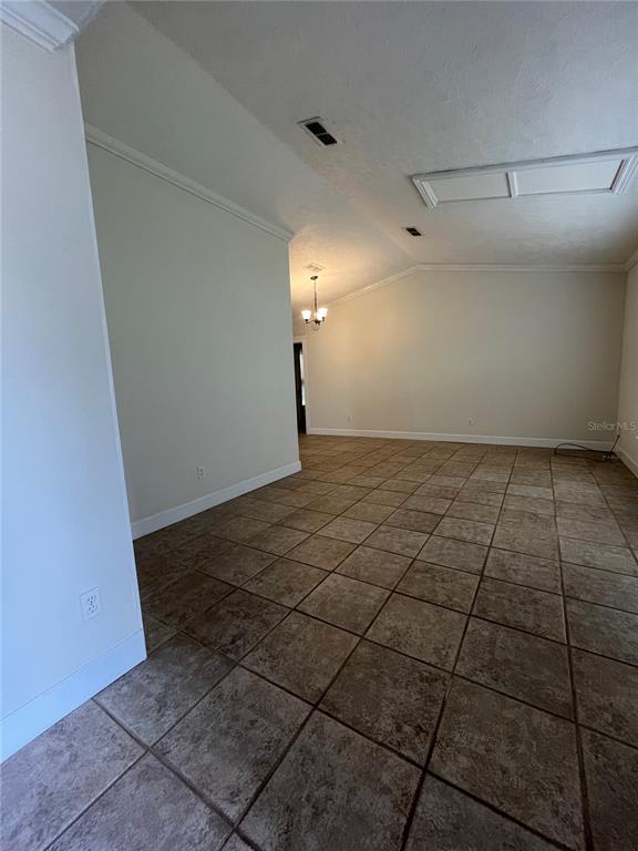 An open living area features vaulted ceilings, tile flooring, and a chandelier in the distance — 3222 HAMMERSMITH ROAD, ORLANDO, FL