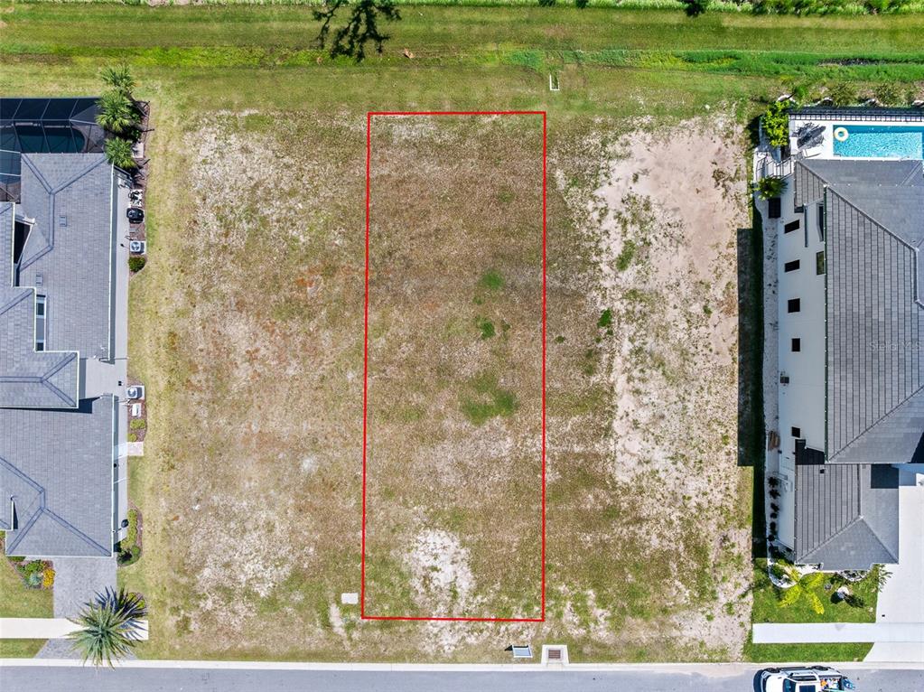 An aerial view shows a vacant rectangular residential lot outlined in red between two houses — 48 CORONADO ROAD, FLAGLER BEACH, FL