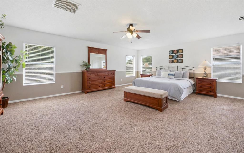 A living room with brown sofas, a coffee table, a television, and a ceiling fan — 111 ALDRIDGE LANE, DAVENPORT, FL