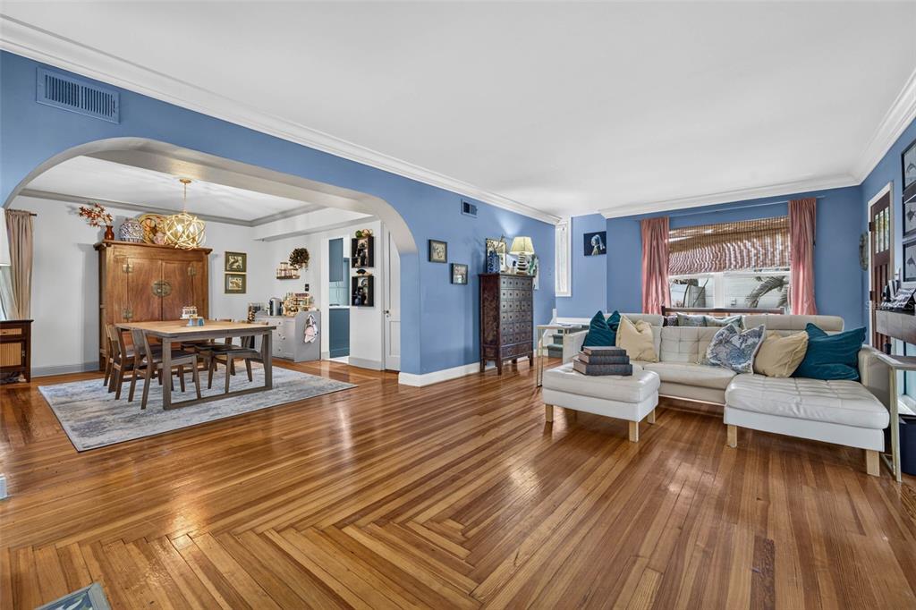 A living and dining room with blue walls, hardwood floors, and an arched entryway — 736 30TH AVENUE N, ST PETERSBURG, FL