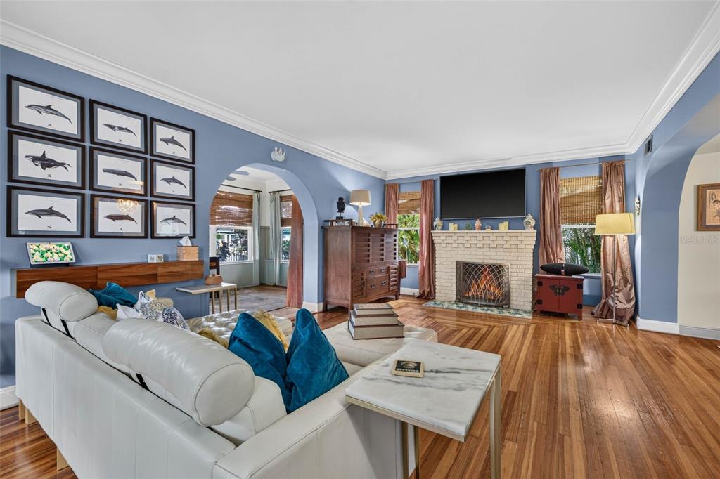 A living room with blue walls, hardwood floors, a white fireplace, and a white sofa — 736 30TH AVENUE N, ST PETERSBURG, FL