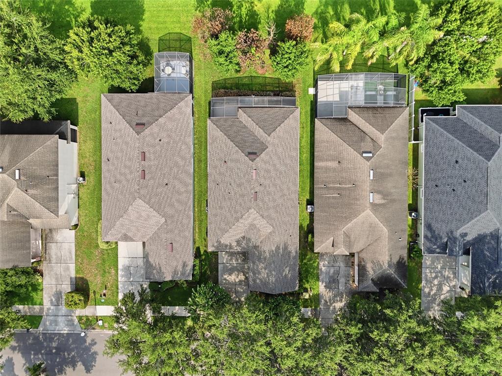 An aerial view shows three suburban houses with screened-in lanais and driveways — 13137 PENSHURST LANE, WINDERMERE, FL