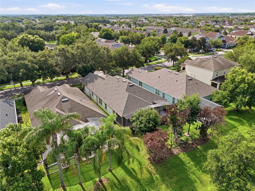 An aerial view shows several suburban houses with shingled roofs and screened-in lanais — 13137 PENSHURST LANE, WINDERMERE, FL