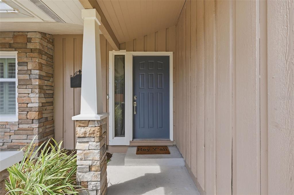 A front entryway features a blue door, a stone pillar, and vertical wood siding — 13917 76TH TERRACE, SEMINOLE, FL