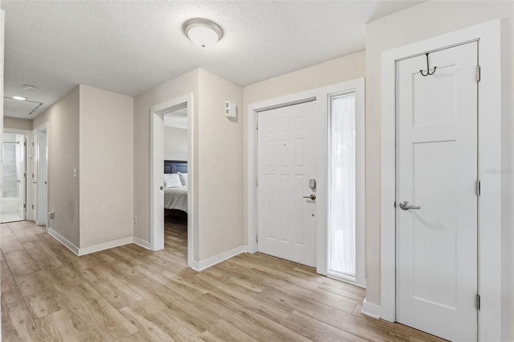 An entryway features light wood-look flooring, a white front door, and a closed interior door — 13917 76TH TERRACE, SEMINOLE, FL