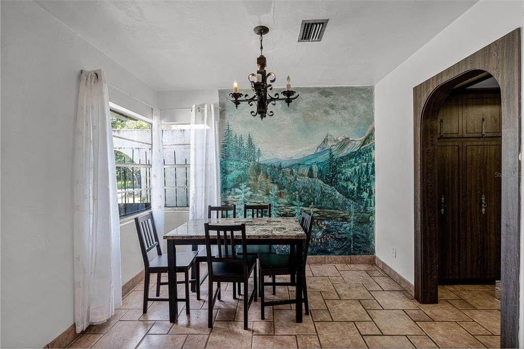 A dining room features a mountain mural, a stone-topped table, and tiled flooring — 7625 CLARCONA OCOEE ROAD, ORLANDO, FL