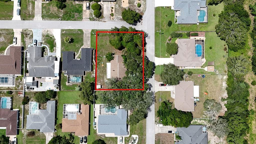 An aerial view shows a single-family home on a lot outlined in red — 1042 TRYON CIRCLE, SPRING HILL, FL