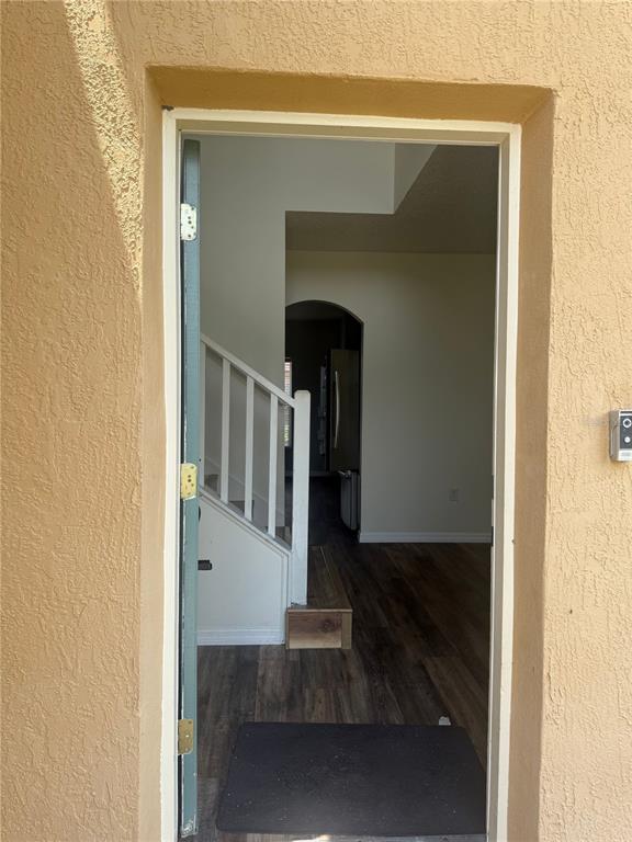 An open doorway reveals an interior entryway with a staircase and wood-look flooring — 401 MALLARD WAY, KISSIMMEE, FL