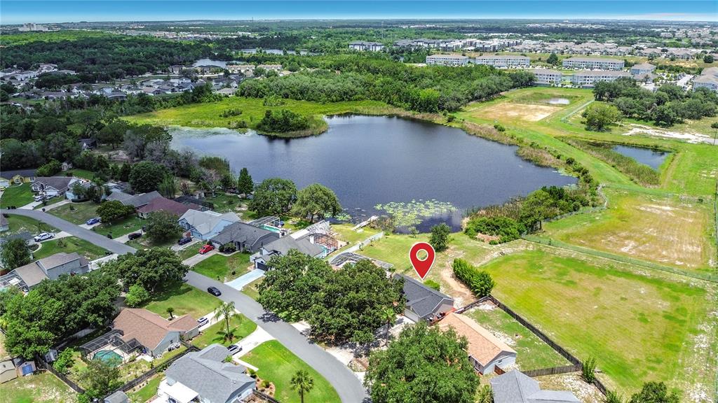 An aerial view shows a suburban house with a red location pin near a lake — 210 ROBBINS REST CIRCLE, DAVENPORT, FL