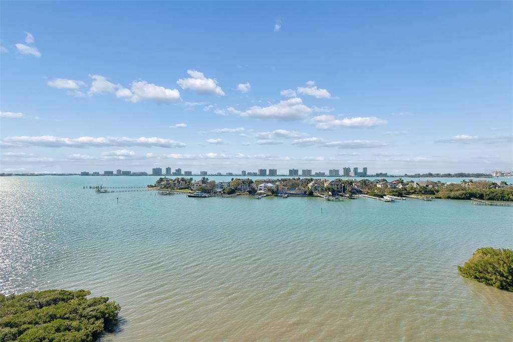 A balcony with outdoor furniture overlooks a bay with a distant city skyline — 4 BELLEVIEW BOULEVARD UNIT 701, BELLEAIR, FL