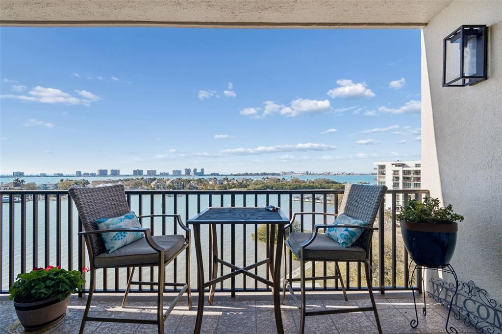 An aerial view shows a multi-story apartment building situated between a golf course and water — 4 BELLEVIEW BOULEVARD UNIT 701, BELLEAIR, FL