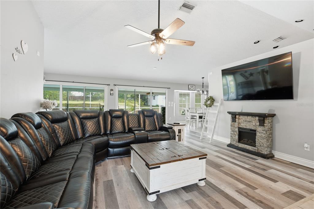 A covered patio features tiled flooring, black outdoor furniture, and a front door with shutters — 4353 W PINE RIDGE BOULEVARD, BEVERLY HILLS, FL