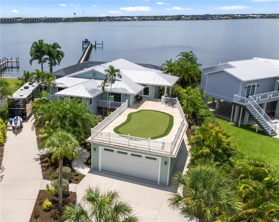 An aerial view shows a long wooden dock extending into a river from a residential property — 818 NANCY GAMBLE LANE, ELLENTON, FL