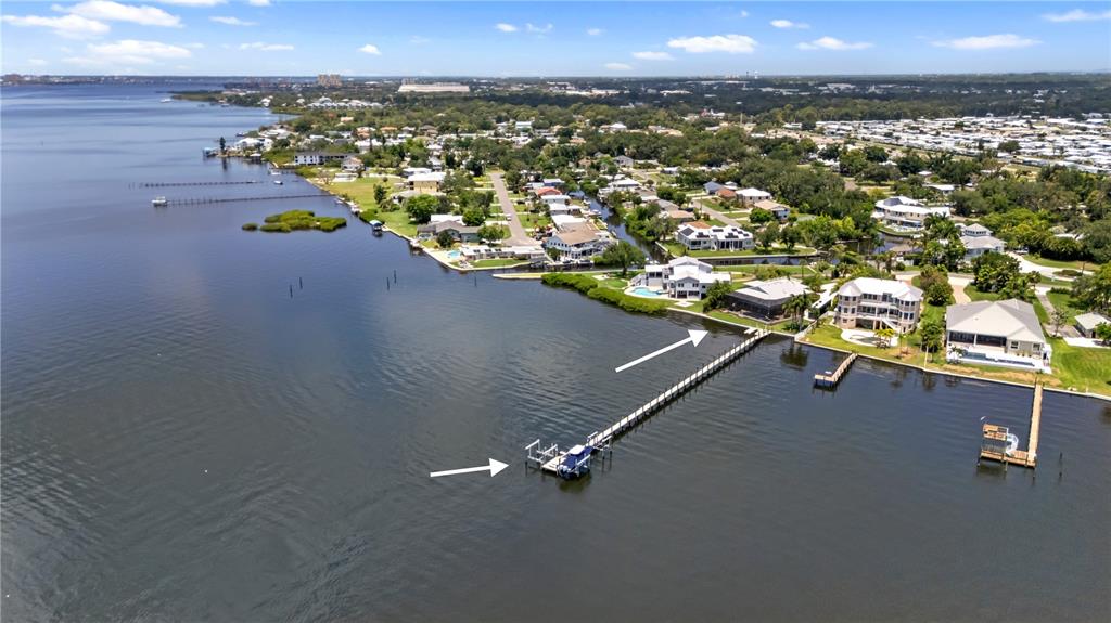 A light green house with a concrete driveway, palm trees, and a rooftop deck — 818 NANCY GAMBLE LANE, ELLENTON, FL