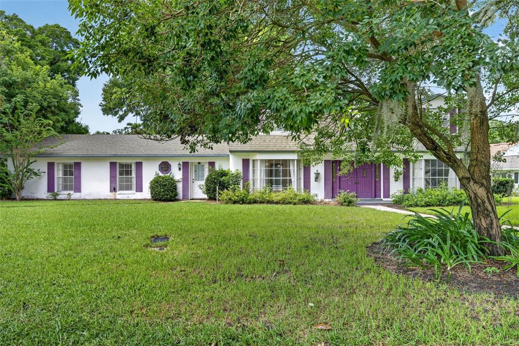 A white two-story house with purple shutters and a large tree in the front yard — 60 OAKLEIGH LANE, MAITLAND, FL