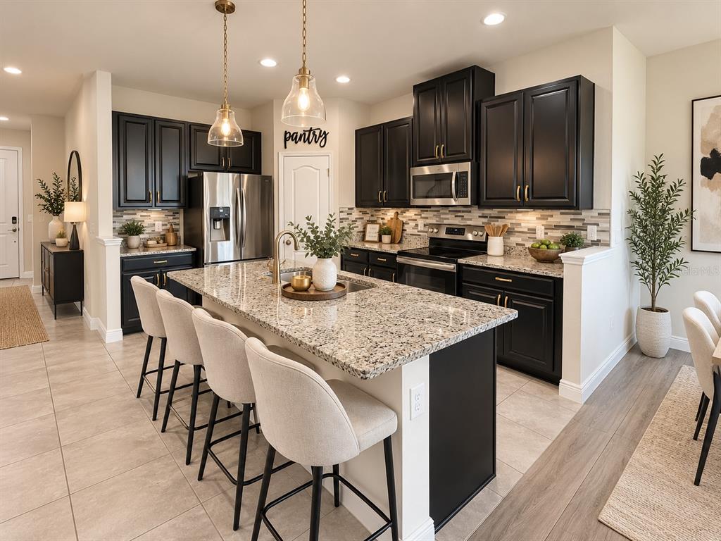 An open-concept living area features a dining table, kitchen with dark cabinets, and a sofa — 2749 PLEASANT CYPRESS CIRCLE, KISSIMMEE, FL