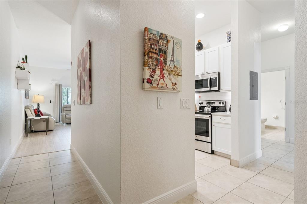 A hallway leads to a living room on the left and a kitchen on the right — 207 LUCAYA LOOP UNIT 207, DAVENPORT, FL