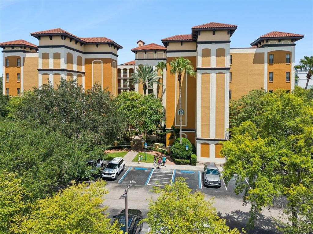 An exterior view of a multi-story apartment building with a parking lot in front — 12539 FLORIDAYS RESORT DRIVE UNIT 102D, ORLANDO, FL