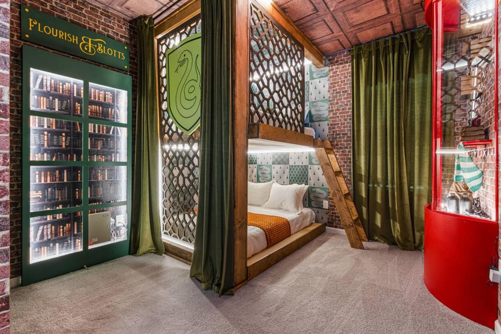 A bedroom features a king bed, a dark wood dresser, and a built-in shelving unit — 5943 HIGH SEAS DRIVE, ORLANDO, FL