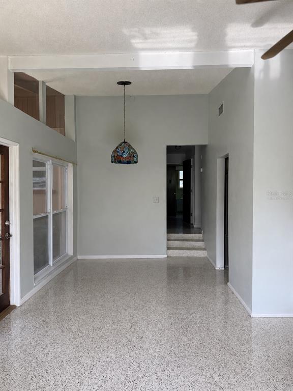 A covered patio with a brick floor, a glass-paned door, and a small bistro set — 2843 BAY STREET, SARASOTA, FL