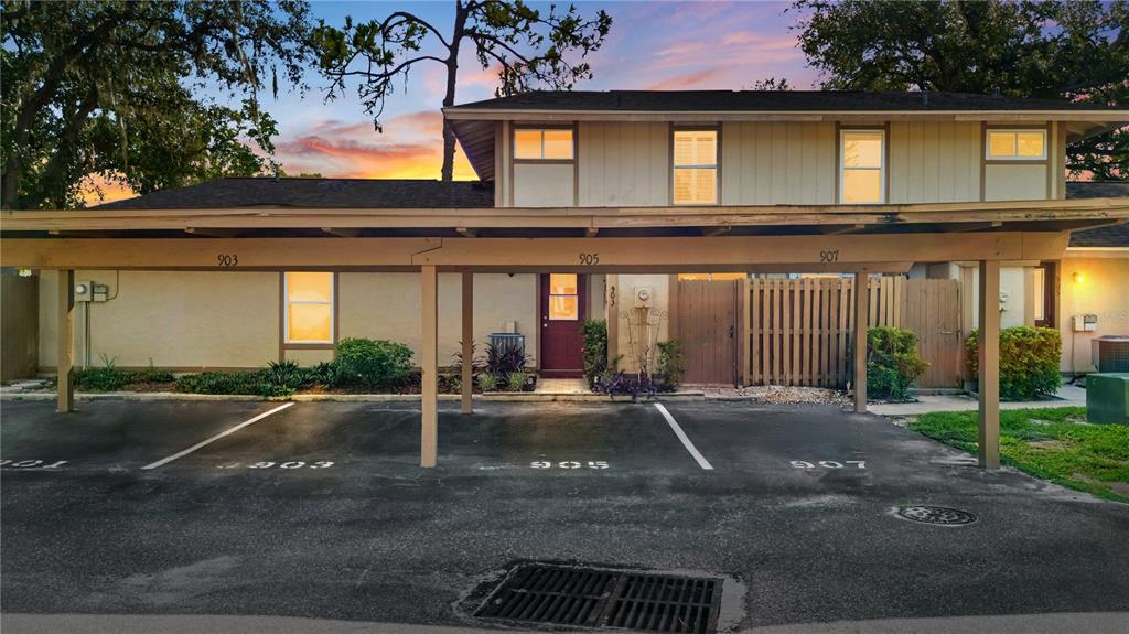 A two-story building exterior features a covered carport with three numbered parking spaces — 903 BUCK COURT, BRANDON, FL