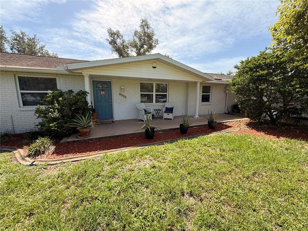 A single-story house with a white brick exterior, a blue front door, and a covered porch — 6510 SUNRIDGE DRIVE, RIVERVIEW, FL