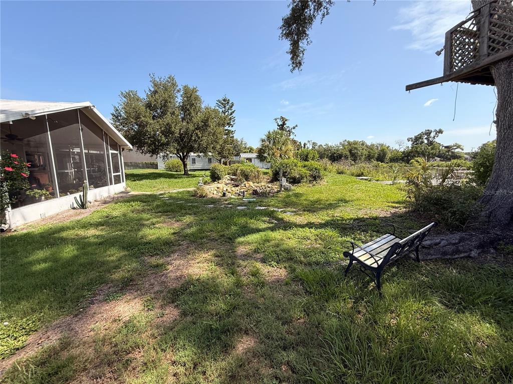 A single-story house with a white brick exterior, a large tree, and an attached carport — 6510 SUNRIDGE DRIVE, RIVERVIEW, FL