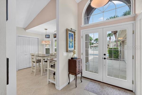 An entryway with tile floors, a wooden chest, and a dining area visible through an opening — 54 SHINNECOCK DRIVE, PALM COAST, FL