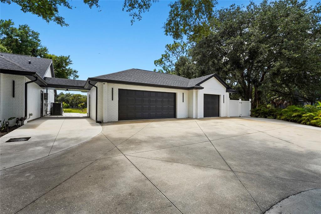 A white brick house with black trim and a concrete walkway leading to the entrance — 906 136TH STREET E, BRADENTON, FL
