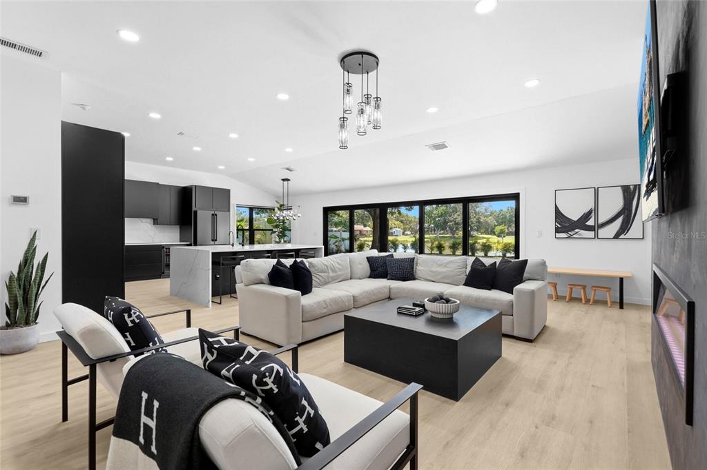 A white brick garage with a black roof and doors sits beside a concrete driveway — 906 136TH STREET E, BRADENTON, FL