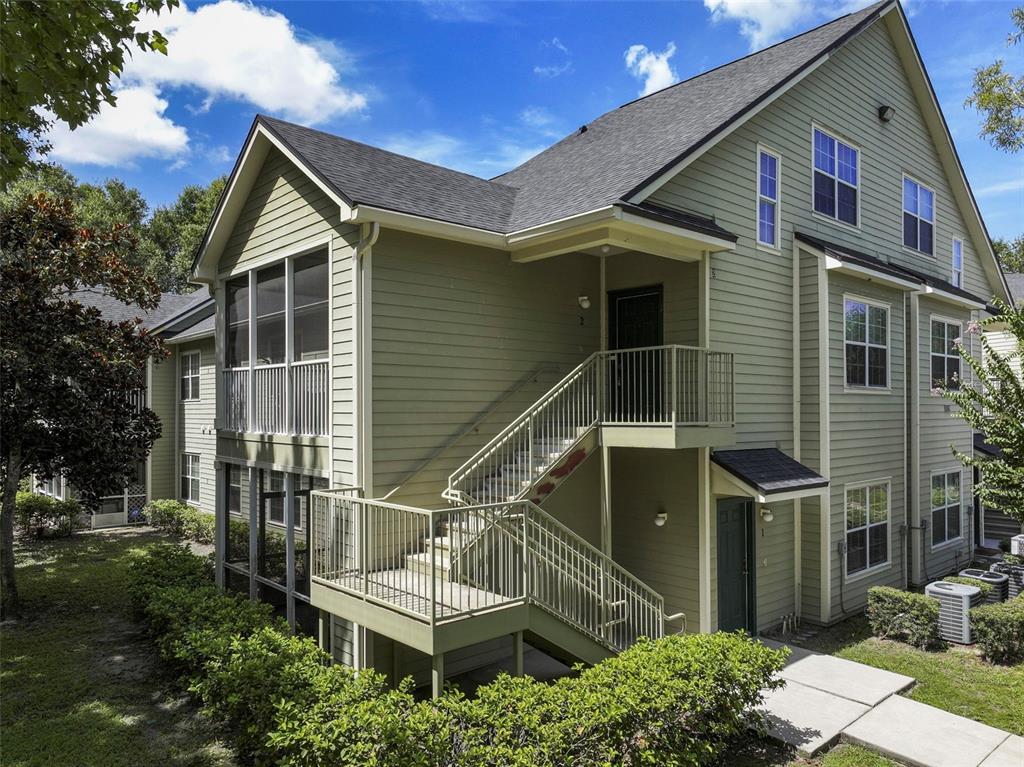 A two-story apartment building with light green siding, a screened porch, and exterior staircases — 3719 S LAKE ORLANDO PARKWAY UNIT 2, ORLANDO, FL