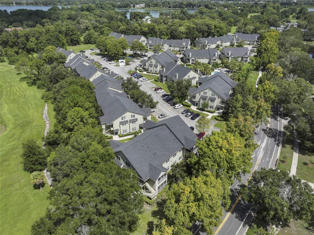 An aerial view shows a multi-building apartment complex surrounded by trees and a nearby lake — 3719 S LAKE ORLANDO PARKWAY UNIT 2, ORLANDO, FL