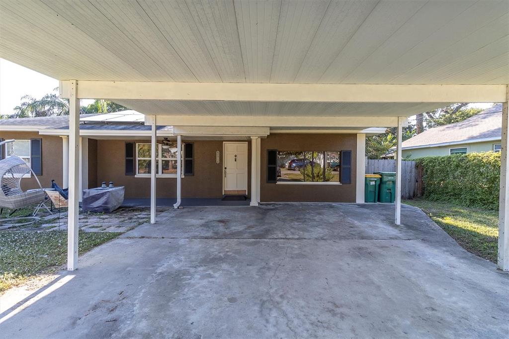 A concrete driveway leads to a covered carport attached to the front of a house — 1797 RAINBOW BOULEVARD, CLEARWATER, FL
