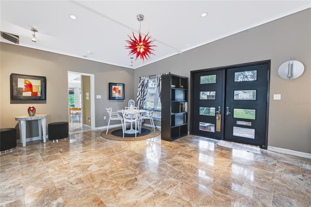 A dining area with a red chandelier, marble floors, and double black front doors — 600 MAYFAIR CIRCLE, ORLANDO, FL