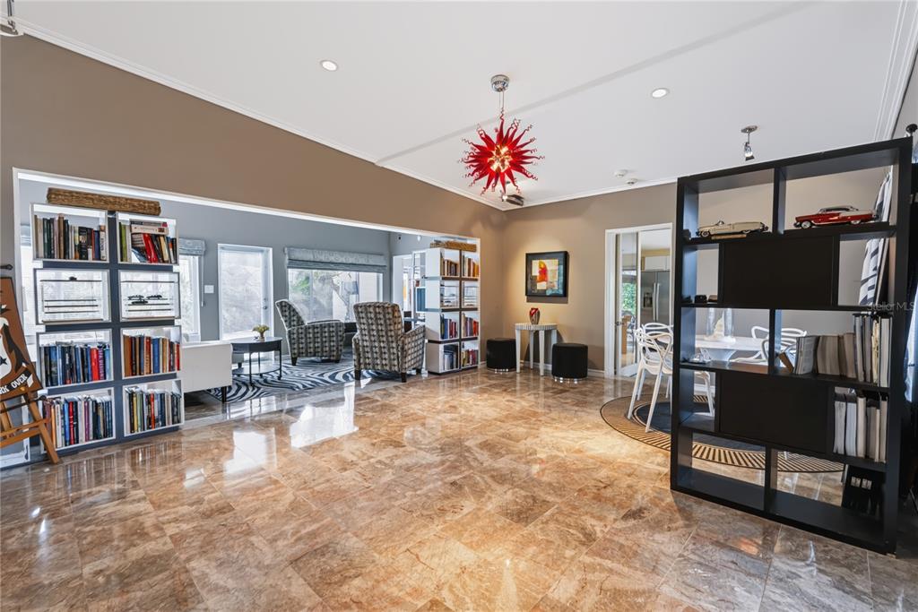 A spacious living room features marble tile flooring, a red chandelier, and two open bookshelves — 600 MAYFAIR CIRCLE, ORLANDO, FL