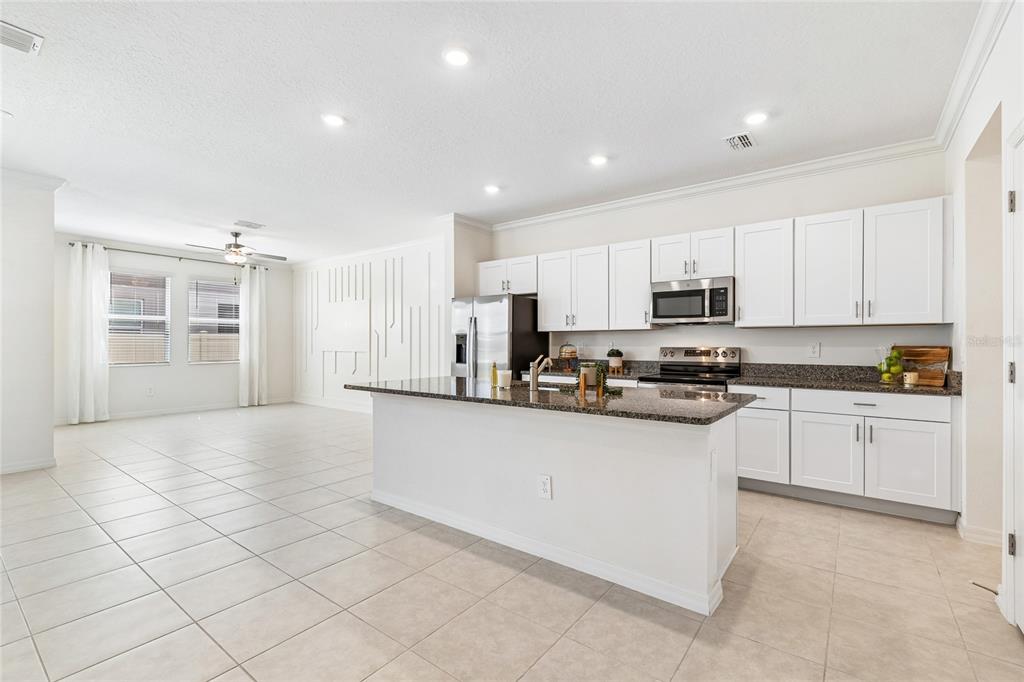 A kitchen with white cabinets, granite countertops, stainless steel appliances, and a central island — 10811 FOWLERS BLUFF COURT, TAMPA, FL