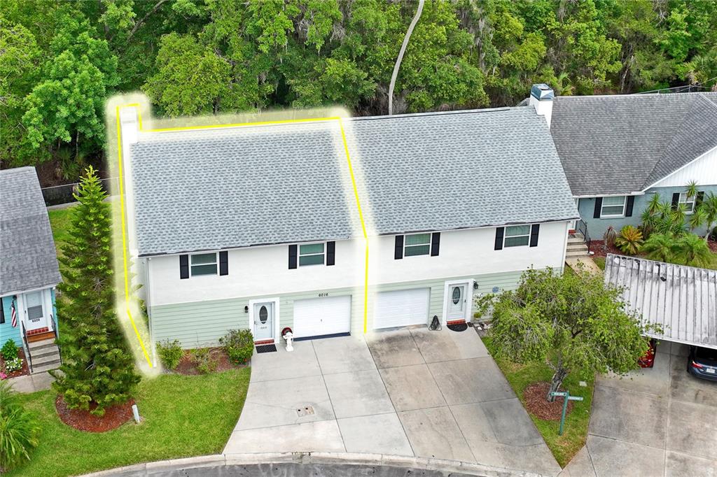 An aerial view shows a two-story duplex with a gray shingled roof and concrete driveways — 6016 WILDS DR, NEW PORT RICHEY, FL