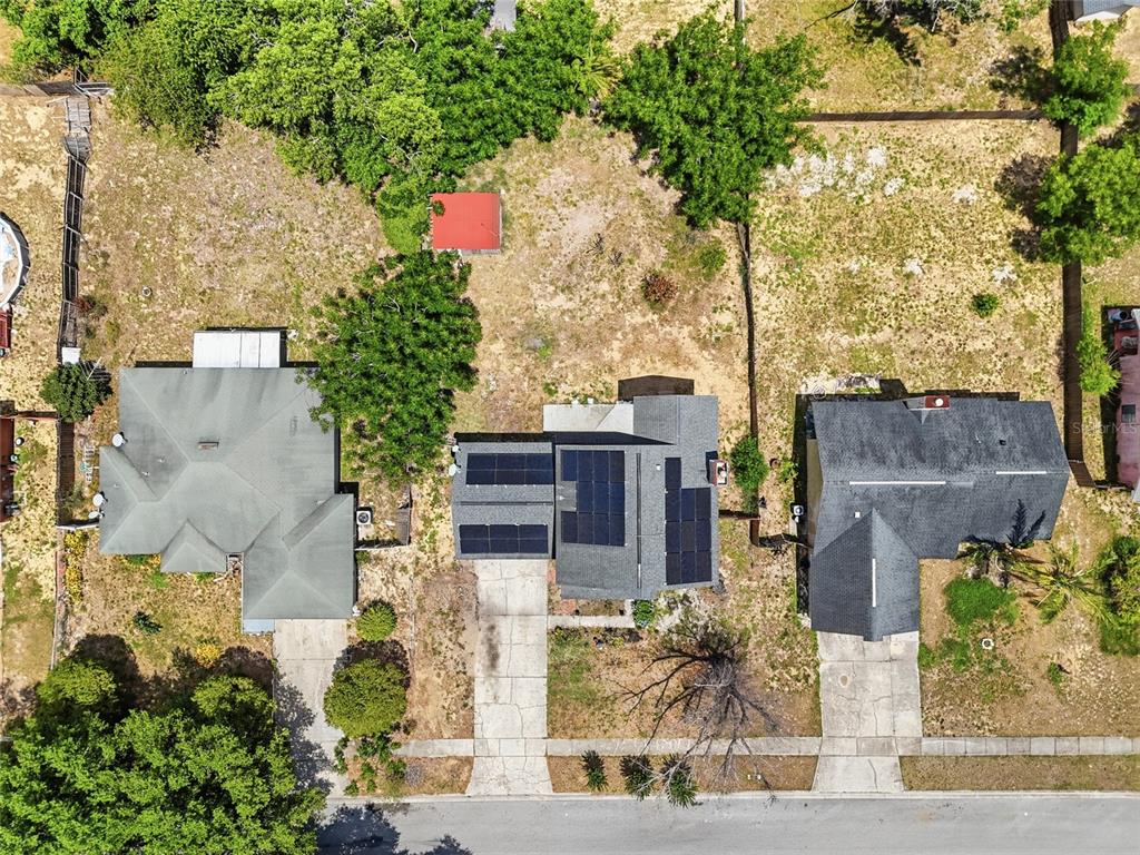 An aerial view shows three houses with driveways and yards along a residential street — 3027 QUEENSGATE ROAD, ORLANDO, FL