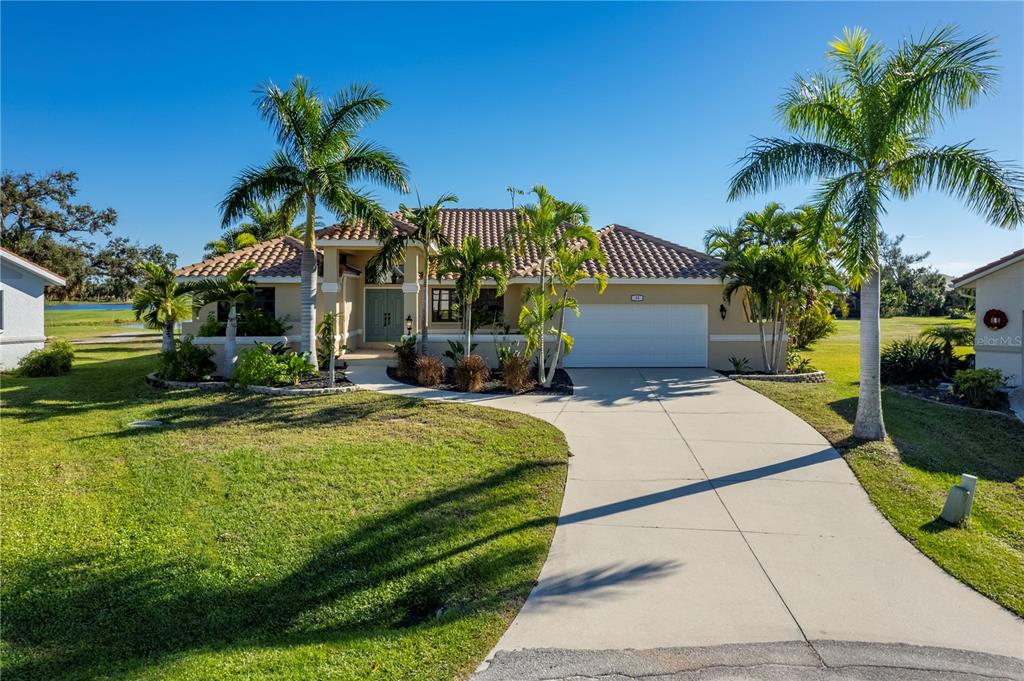 A single-story house with a tile roof, two-car garage, and palm trees in the front yard — 13 SEAWARD CIRCLE, PLACIDA, FL
