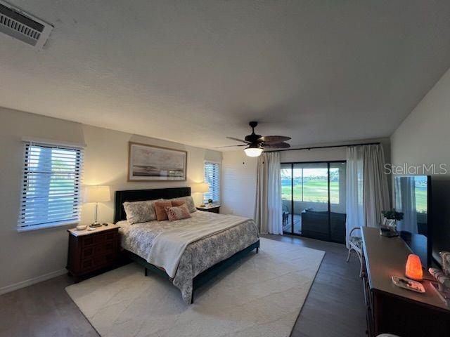 A bedroom features a king bed, ceiling fan, and sliding glass doors overlooking a golf course — 13 SEAWARD CIRCLE, PLACIDA, FL