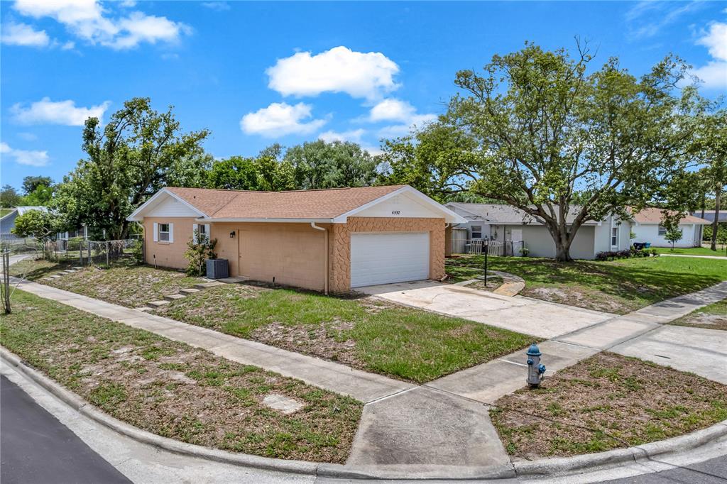 An empty room with light wood-look flooring, white walls, recessed lighting, and an arched doorway — 4992 E WIND STREET, ORLANDO, FL